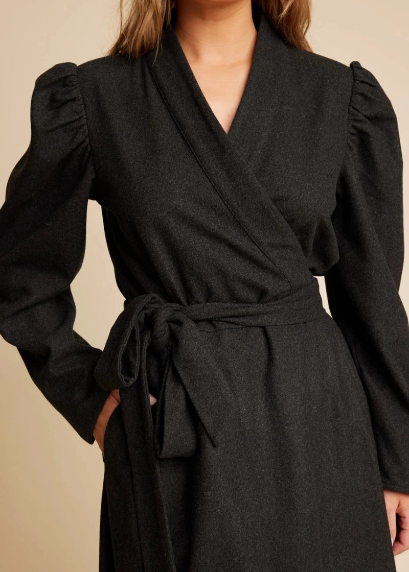 woman wearing black wool wrap dress with belt Line of Oslo Scarlett dress