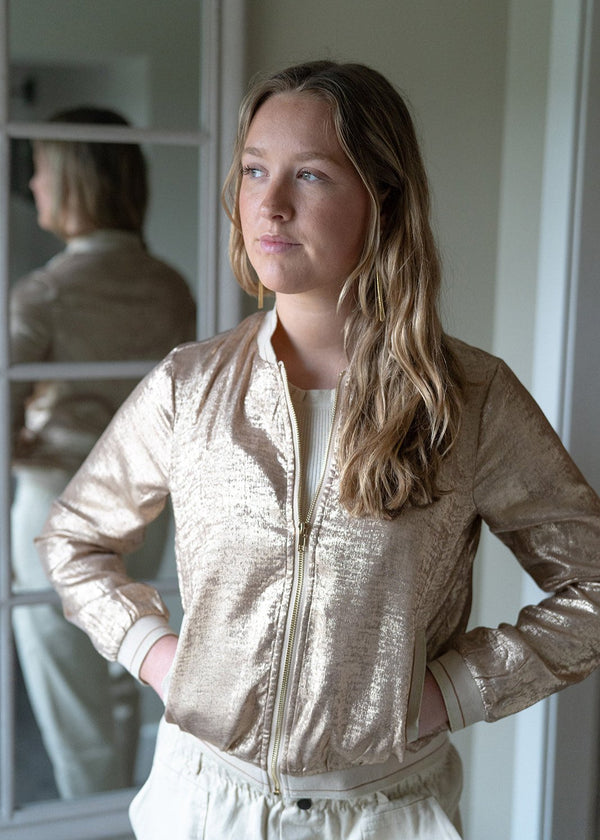 woman wearing a soft gold bomber jacket