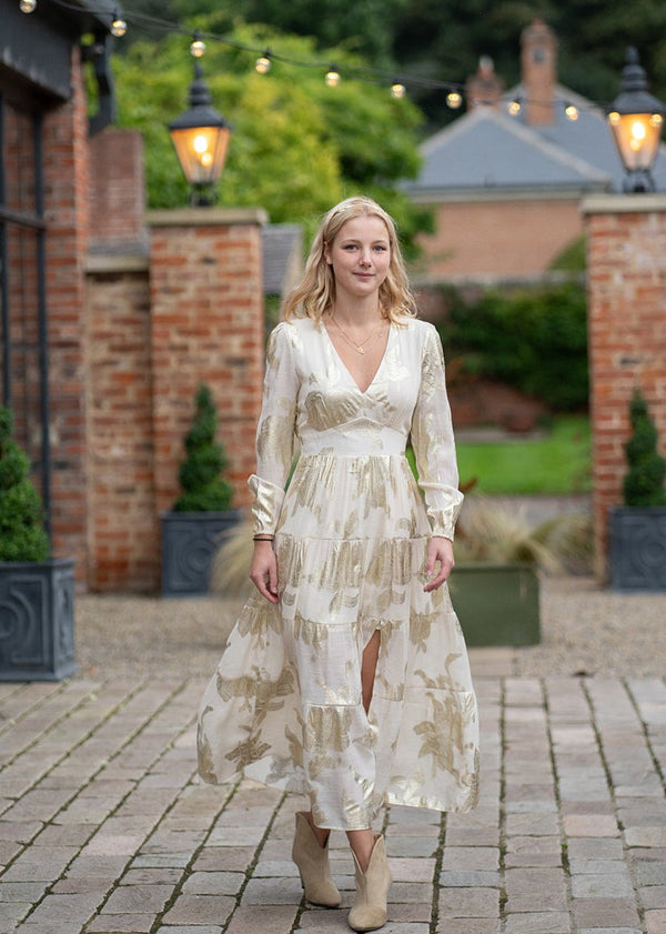 woman wearing Ruby dress maxi cream dress with gold 