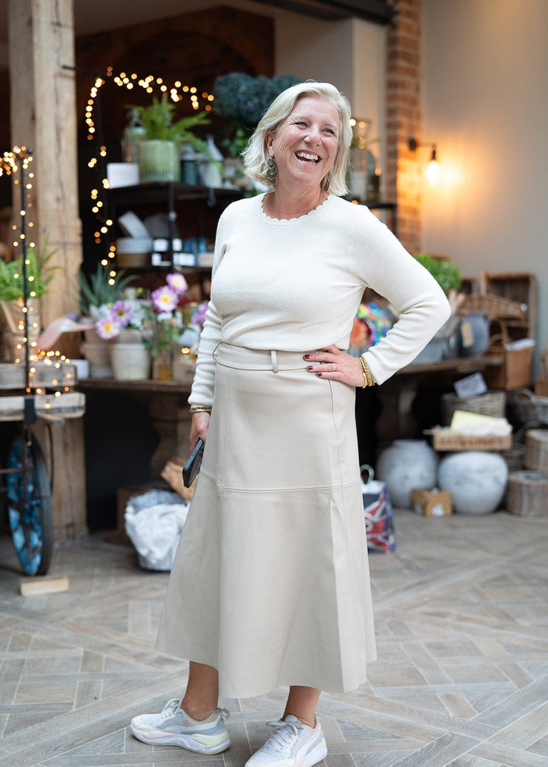 woman wearing cream jumper with scalloped edge neckline