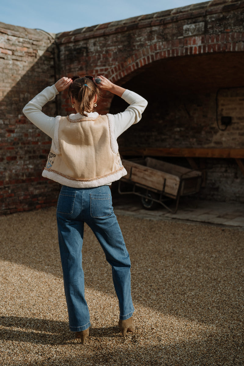 women wearing jeans and a gilet on a farmyard 