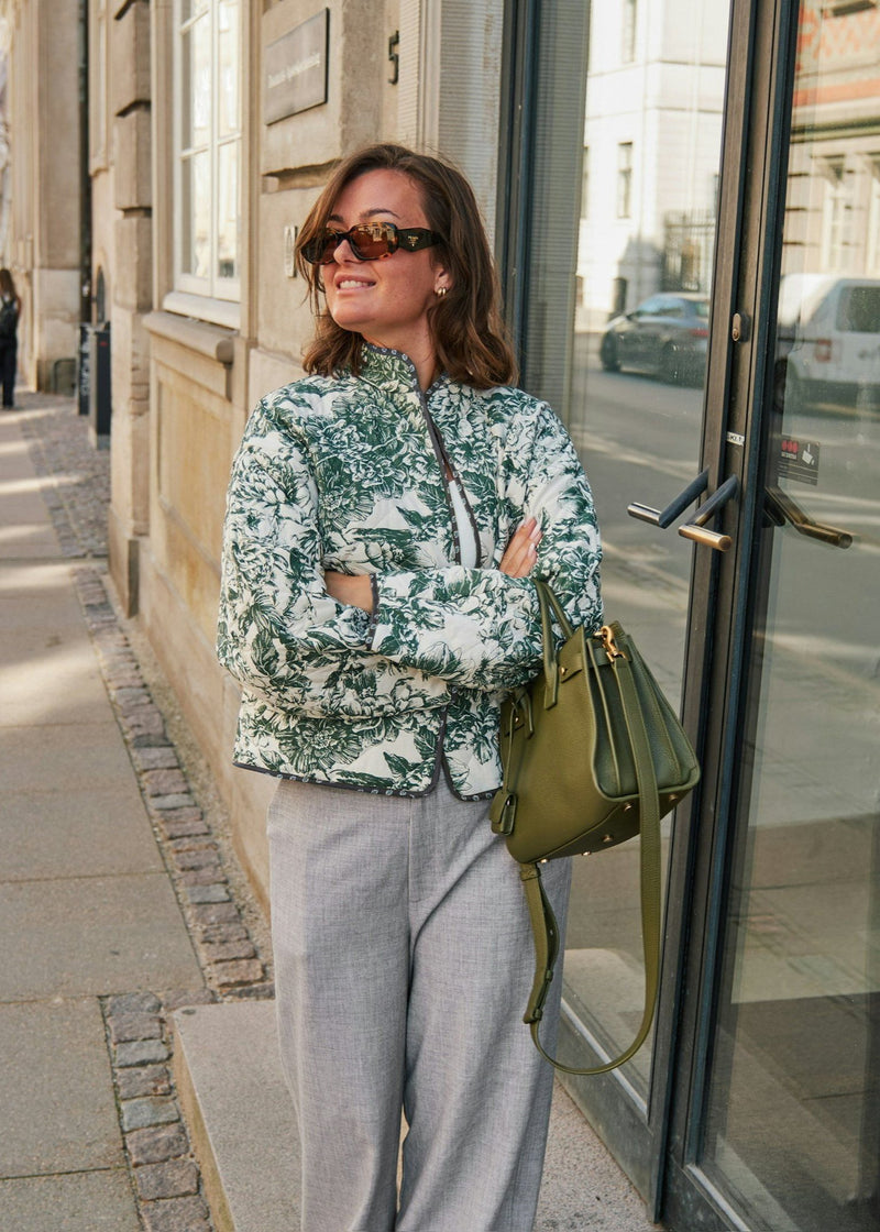 woman wearing a green and white floral jacket